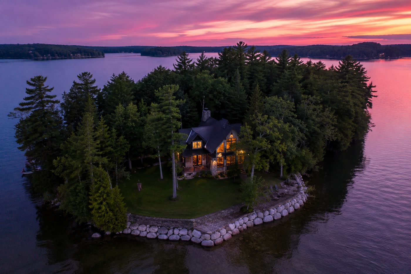 A private island compound on Lake Minnetonka, Minnesota, glowing at dusk